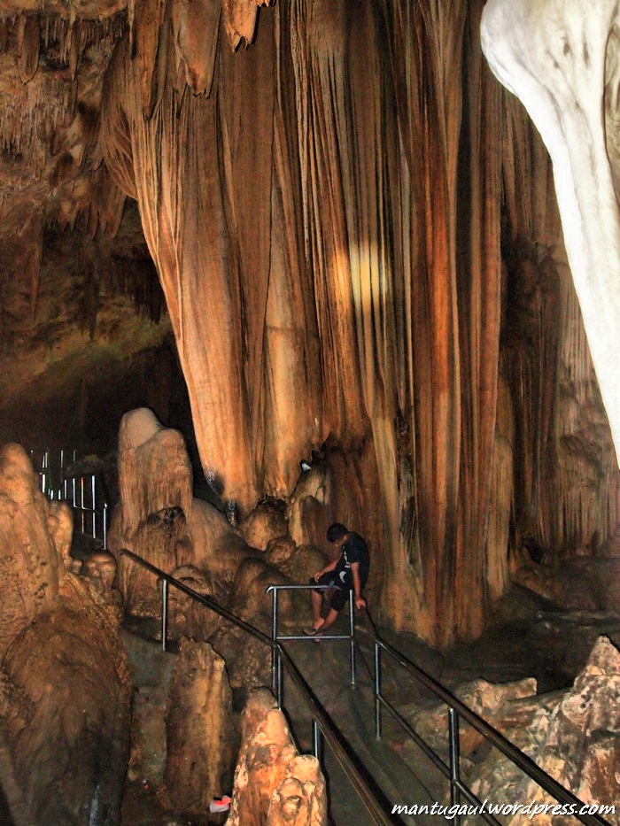 Liat perbandingan stalaktit dan pengunjung yang berpakaian hitam